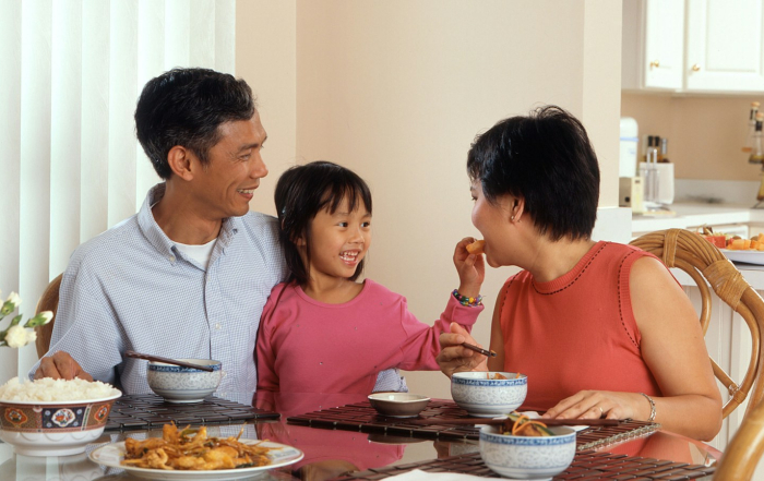 Familia reunida alrededor de la mesa durante una comida cotidiana.