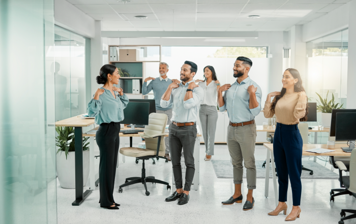 Trabajadores mestizos practican una pausa activa guiada en una oficina luminosa. Imagen ilustrativa generada con IA.