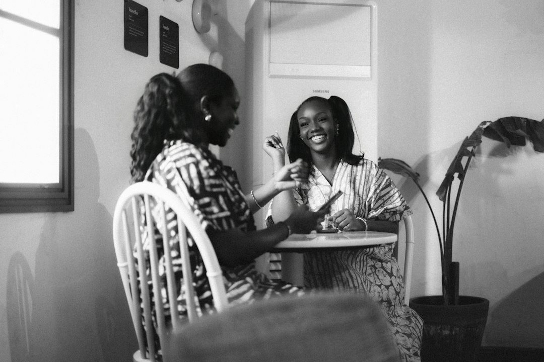 MentalMente Eventos | Brunch de solteros Dos mujeres afrodescendientes conversando y sonriendo en una mesa, foto ilustrativa